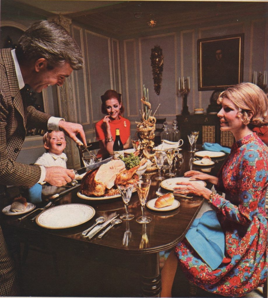 Photo of three adults and a child sitting down to a turkey dinner